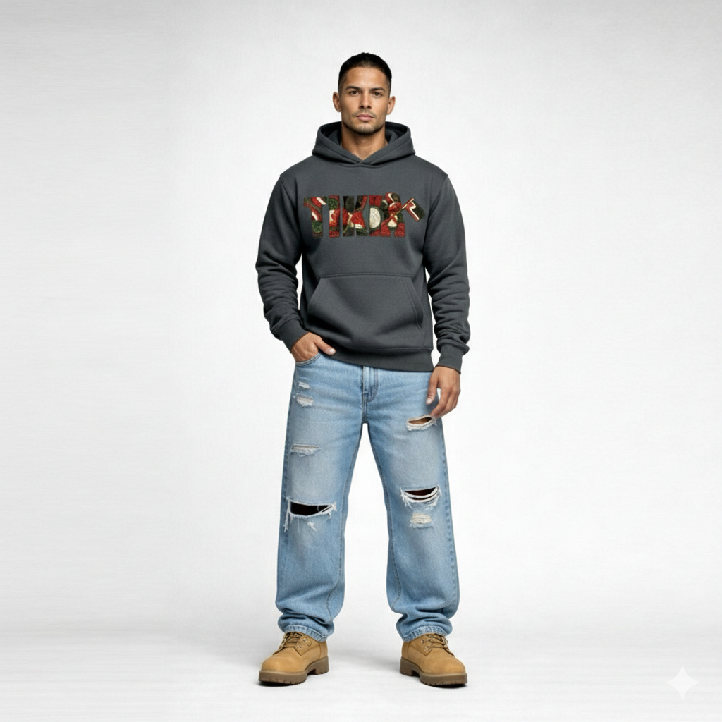 Male model wearing Cravass Tiki hoodie in charcoal grey with Māori-inspired TIKI woven graphic, streetwear fit, front view