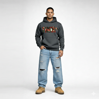 Male model wearing Cravass Tiki hoodie in charcoal grey with Māori-inspired TIKI woven graphic, streetwear fit, front view