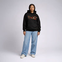 Front-facing female model in Cravass Tiki hoodie featuring Māori-inspired TIKI artwork and textured woven streetwear graphic