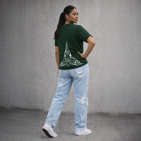Person wearing a green t-shirt with a design on the back and light blue jeans against a gray background
