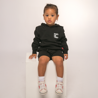 Front view of Te Kara Toi Tu Tiriti Kids Hoody in black, featuring 'Toitū te Tiriti' text