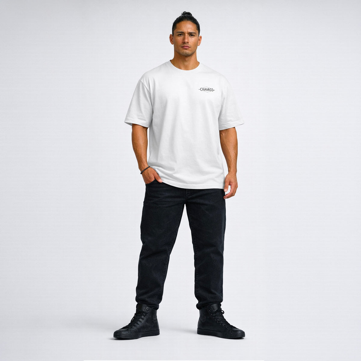 Man wearing a white t-shirt and black pants on a plain background Tapawha Māori Streetwear Tee by Cravass – Black on white T-Shirt NZ
