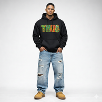 Male model wearing black Cravass TIKI statement hoodie with Rasta colour Māori-inspired graphic, streetwear fit, New Zealand design