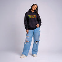 Model wearing black Cravass TIKI statement hoodie with colourful Māori-inspired graphic, streetwear fit, New Zealand design