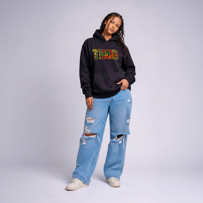 Model wearing black Cravass TIKI statement hoodie with colourful Māori-inspired graphic, streetwear fit, New Zealand design