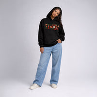 Front view of female model wearing Cravass Tiki hoodie in black with Māori TIKI graphic, modern streetwear style