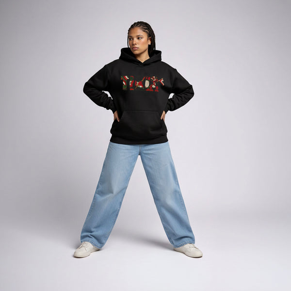 Female model wearing Cravass Tiki hoodie in Black with Māori-inspired TIKI woven graphic, streetwear fit, front view