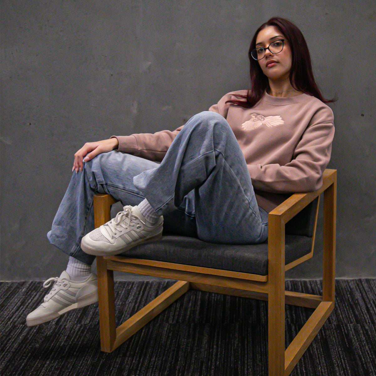 Woman wearing Cravass Pīwakawaka Hazy Pink Women's Crew with embroidered native bird artwork