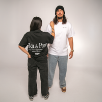 Two people wearing black and white t-shirts with visible Tika & Pono branding against a plain background