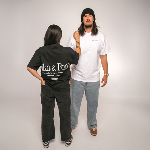 Two people wearing black and white t-shirts with visible Tika & Pono branding against a plain background
