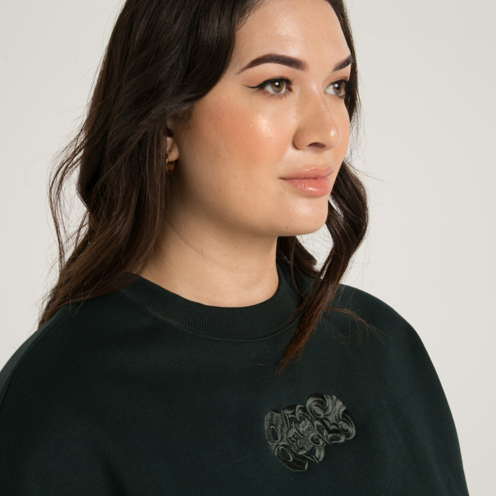 Women's pine green jersey with original Hei Tiki design immaculately embroidered to give shape and definition bringing him to life. Maori clothing.