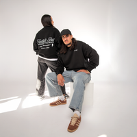 Black oversized Toitū te Tiriti Māori typography crew worn by model
