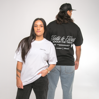 Two people wearing white and black t-shirts with Maori text, standing side by side against a plain background.