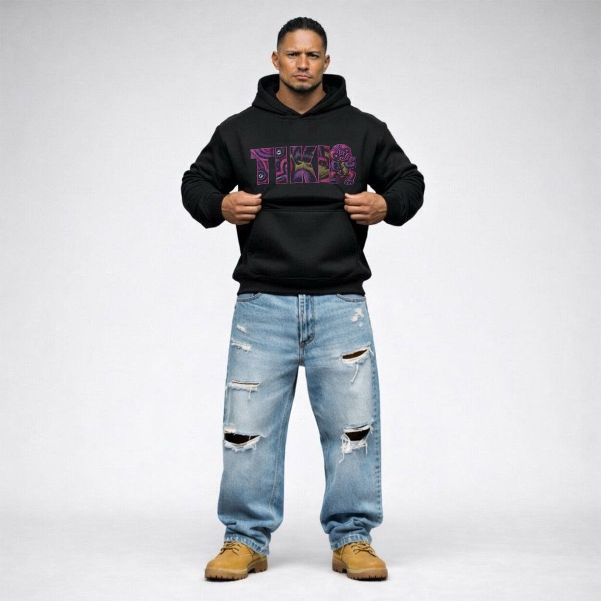 Cravass Waiporoporo black hoodie from Tiki Collection, bold purple Māori-inspired chest graphic, men’s streetwear studio photography