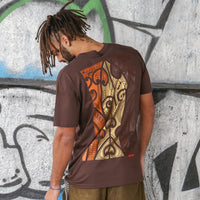 Men's brown t-shirt with copper, brown and brown Maori art and design on the back.