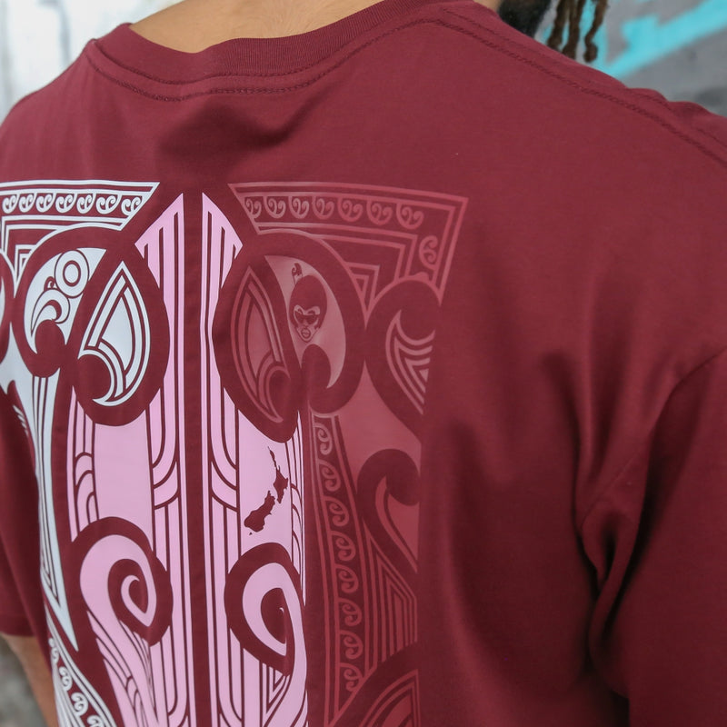 Men's burgundy t-shirt with pink, white and burgundy Maori art and design on the back.