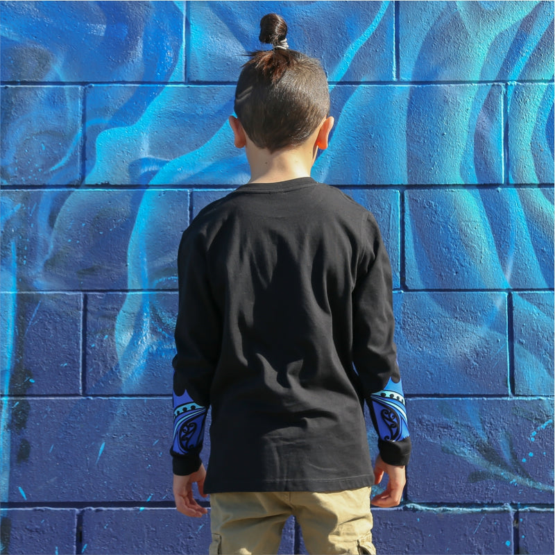 Young boy wearing black long sleeve tshirt with blue maori design on the forearm form cravass clothing. Back