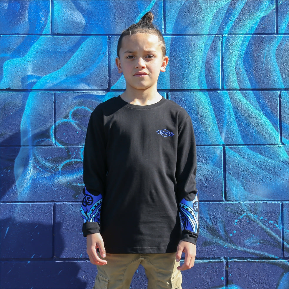 Young boy wearing black long sleeve tshirt with blue maori design on the forearm form cravass clothing. front