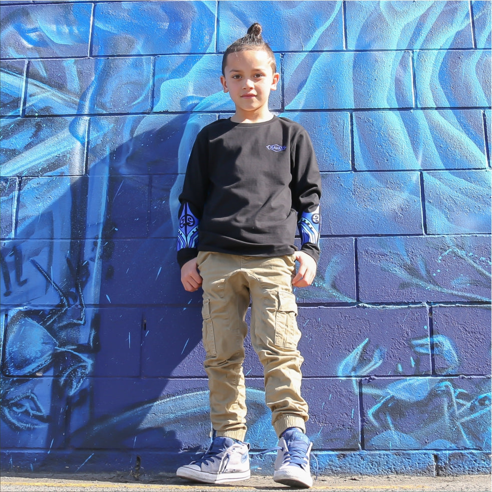 Young boy wearing black long sleeve tshirt with blue maori design on the forearm form cravass clothing.