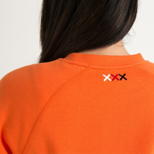 Women's orange crew jersey with white Maori poutama design from Cravass clothing - back view