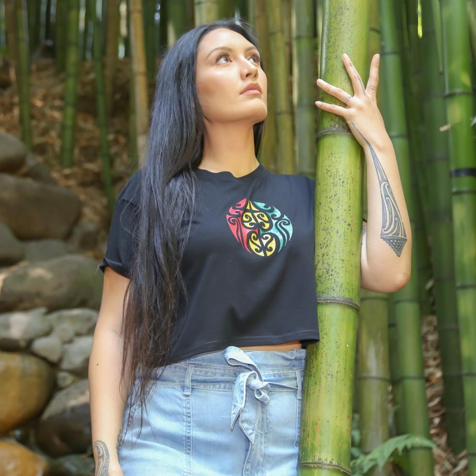 Women's black crop top with Rasta coloured Maori design from Cravass Clothing.