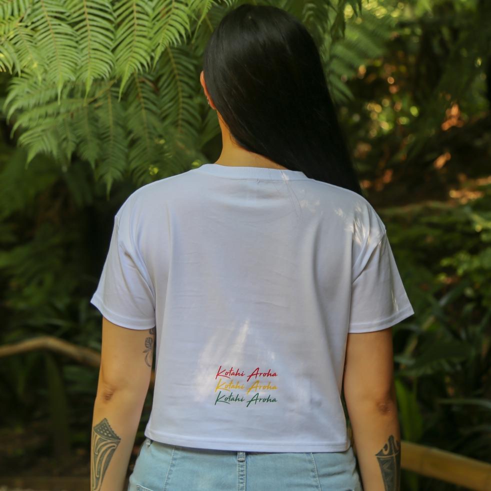 Women's white crop top with Rasta coloured Maori design from Cravass Clothing. Back