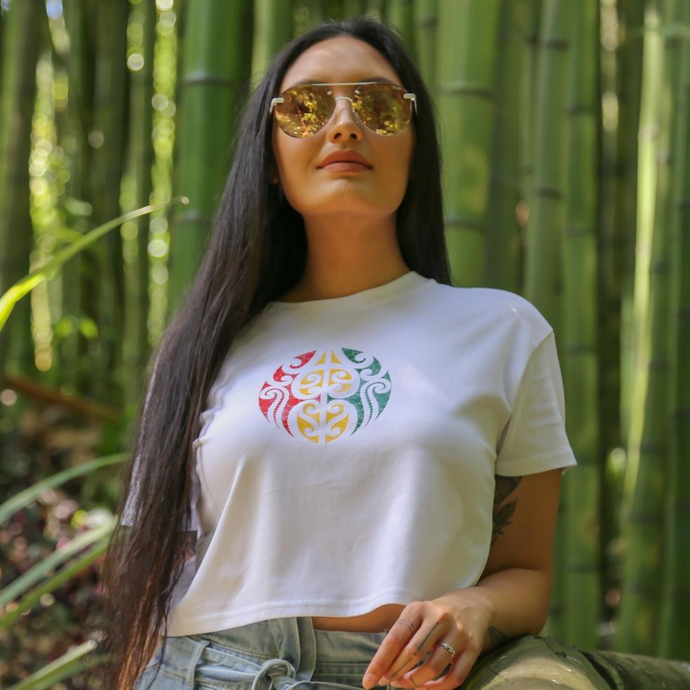 Women's white crop top with Rasta coloured Maori design from Cravass Clothing.