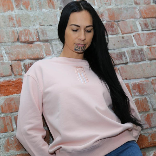 Model wearing pink jersey with a moko kauae embroidered maori design