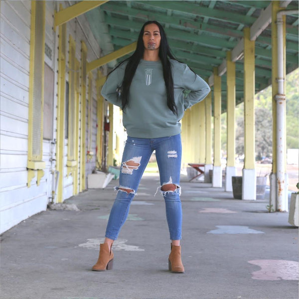 Beautiful sage women's crew with embroidered Moko Kauae design. Standing under the gisborne railway station nz 