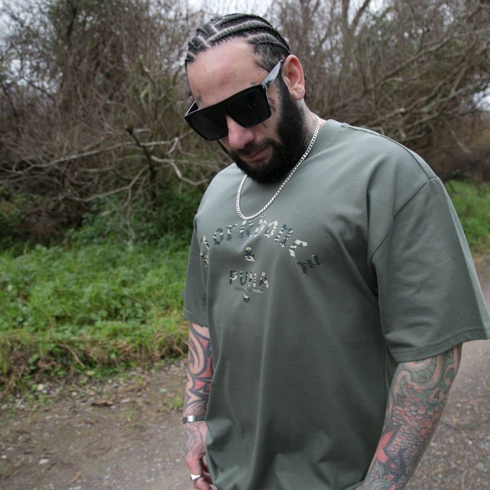 Men's Green heavyweight T-shirt with Camo Pork bones and Puha design from cravass clothing.