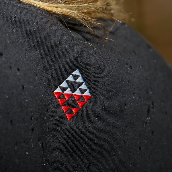 Black women's crew with red and white embroidered Maori taniko design back.