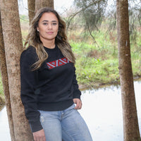 Black women's crew with red and white embroidered Maori taniko design.